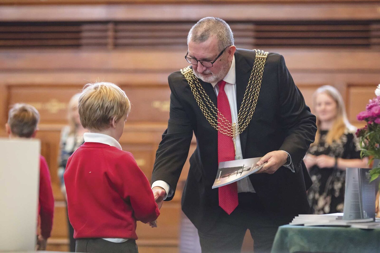 Mayflower-anthology-Cllr-Davey-presents-a-copy-of-the-anthology-to-one-of-the-children-whose-work-was-included-(1)