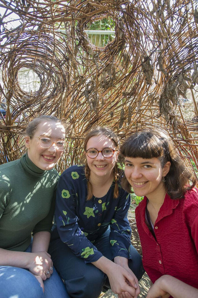 Students Caroline Barr, Vittoria Sutton and Chiarini inside the willow pod